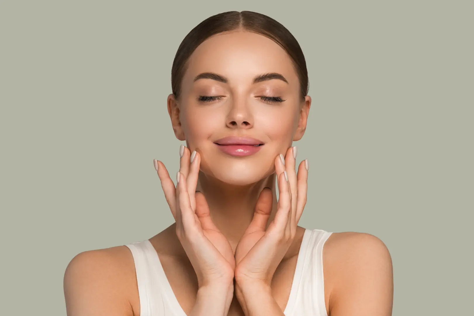 Front-facing woman with closed eyes and both hands resting along her cheeks and jawline.